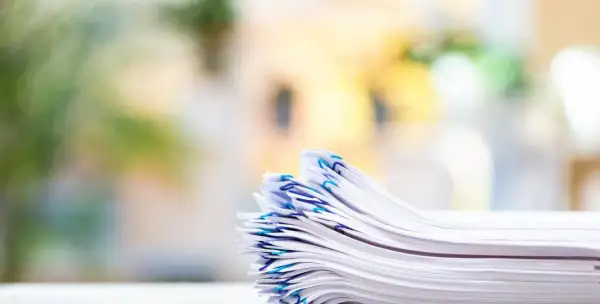 En hög med papper, organiserad med blå gem, som representerar vikten av att följa artikel 30 GDPR för dataskydd.