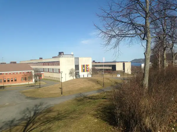 Sanda gymnasiet med sina moderna byggnader och grönområden, en solig dag.