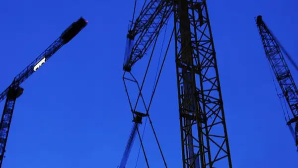 Byggkranar mot en mörkblå himmel. Ett ramavtal för framtida projekt.